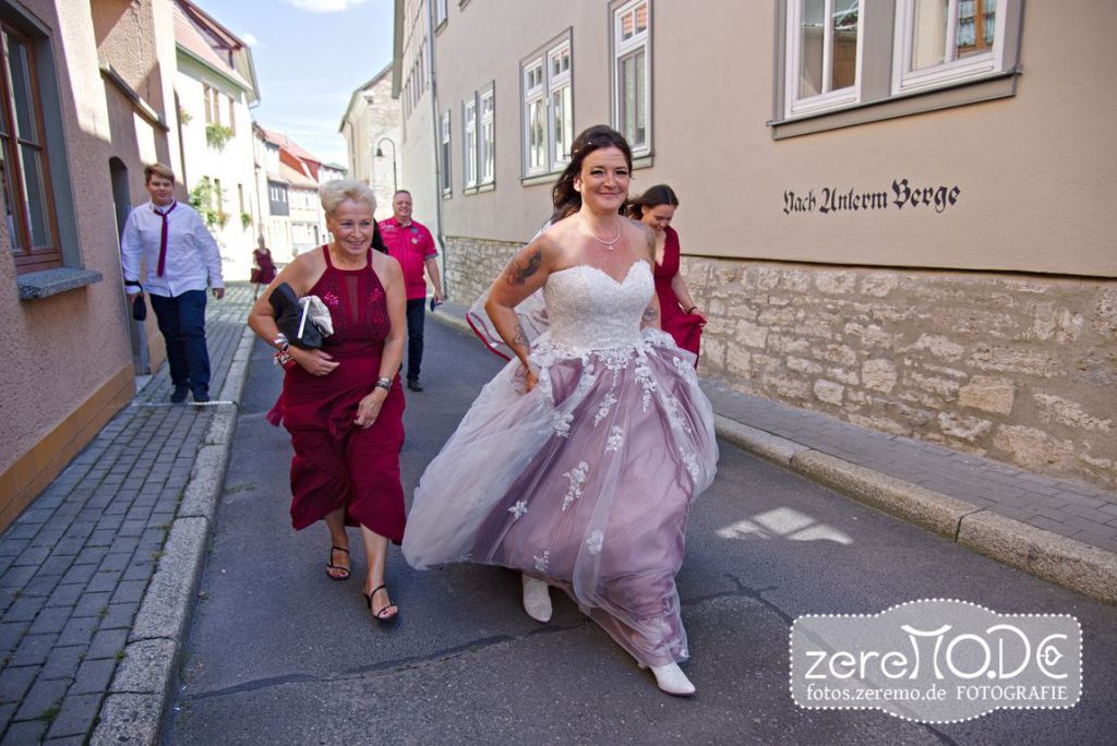 Braut auf dem Weg zur Trauung, der Wind fängt sich im Kleid
