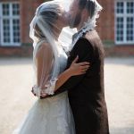 Paarshooting Hochzeitspaar, Braut und Bräutigam küssend unter dem Brautschleier