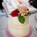 Hochzeitstorte mit roter und pfirsichfarbener Rose